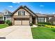 Charming home with a two-car garage, stone accents, and well-manicured landscaping on a sunny day at 123 Mulberry Ct, Peachtree City, GA 30269