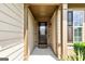 Covered front porch with a decorative front door and sidelight that is accented with siding and stone at 123 Mulberry Ct, Peachtree City, GA 30269