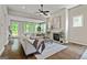 Bright living room with a fireplace, ceiling fan, neutral paint, and a cozy seating area at 123 Mulberry Ct, Peachtree City, GA 30269