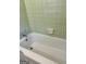 Retro bathroom showcases a classic white bathtub with chrome fixtures and coordinating green tile work at 2334 Connally Dr, East Point, GA 30344