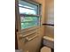 A well-lit bathroom with a window view, safety bars, and classic tiling at 2334 Connally Dr, East Point, GA 30344
