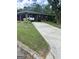 Charming brick home featuring a well-maintained lawn, long drive, and covered parking at 2334 Connally Dr, East Point, GA 30344