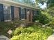 Quaint brick home boasts black shutters and beautiful landscaping, creating an inviting and classic facade at 2334 Connally Dr, East Point, GA 30344