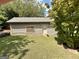 View of a one-story outbuilding with beige siding and brown trim, including a door and window at 2334 Connally Dr, East Point, GA 30344