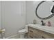 Stylish half bathroom featuring modern vanity, round mirror, and elegant fixtures at 508 Las Brasis Ct, Peachtree City, GA 30269
