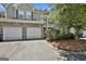 Charming townhome featuring a two-car garage with stone accents, mature landscaping, and neutral siding at 508 Las Brasis Ct, Peachtree City, GA 30269