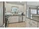 Bright kitchen featuring white cabinets, granite countertops, stainless steel appliances and tile floors at 508 Las Brasis Ct, Peachtree City, GA 30269
