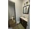 Modern bathroom with a dark vanity, white sink, and tiled floors, showcasing a clean design at 1333 Happy Hill Rd, Carrollton, GA 30116