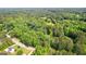 Expansive aerial view of a neighborhood with lush greenery and a sparkling blue pool nestled among the trees at 210 Farr Lake Dr, Tyrone, GA 30290