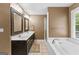 Bathroom featuring a soaking tub, glass-enclosed shower, double vanity, and neutral decor at 210 Farr Lake Dr, Tyrone, GA 30290