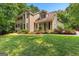 Inviting two-story home with a balcony, well-manicured lawn, and colorful flowerbeds at 210 Farr Lake Dr, Tyrone, GA 30290