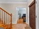 Inviting foyer with wood staircase and neutral paint leads into bright living spaces with beautiful hardwood floors at 210 Farr Lake Dr, Tyrone, GA 30290