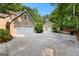View of multiple-car garages and driveway surrounded by lush trees and landscaping on a sunny day at 210 Farr Lake Dr, Tyrone, GA 30290