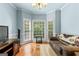 Bright living room featuring bay windows, hardwood floors, and a plush sofa, creating a comfortable space at 210 Farr Lake Dr, Tyrone, GA 30290