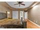 Spacious main bedroom with hardwood floors, ceiling fan, and a large bed at 210 Farr Lake Dr, Tyrone, GA 30290