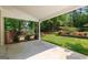 Covered patio providing shade and a view of the large, fenced backyard and greenery at 210 Farr Lake Dr, Tyrone, GA 30290