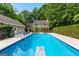 A large inviting pool with a diving board, surrounded by lush greenery and a charming house at 210 Farr Lake Dr, Tyrone, GA 30290