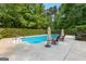 A stunning pool with diving board, surrounded by lush trees and lounge chairs for ultimate relaxation at 210 Farr Lake Dr, Tyrone, GA 30290