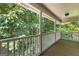 Inviting covered porch with white railings overlooks a lush, wooded landscape at 210 Farr Lake Dr, Tyrone, GA 30290
