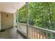 Inviting covered porch with white columns overlooks a lush, green, wooded area offering quiet respite at 210 Farr Lake Dr, Tyrone, GA 30290