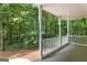 Inviting covered porch with white columns overlooking a beautiful green wooded area, perfect for relaxing at 210 Farr Lake Dr, Tyrone, GA 30290