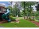 Picturesque backyard with a built-in slide and manicured lawn, offering a private outdoor space at 405 Woodbrook Way, Lawrenceville, GA 30043