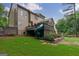 Back exterior view featuring a fun built-in slide, beautiful landscaping, and a well-maintained yard at 405 Woodbrook Way, Lawrenceville, GA 30043