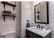 A modern half-bath with shiplap, floating shelves and a dark vanity with a marble top sink at 405 Woodbrook Way, Lawrenceville, GA 30043