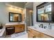 Bathroom featuring wood cabinets, double sinks, large mirrors, and ample lighting at 405 Woodbrook Way, Lawrenceville, GA 30043