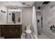Modern bathroom with a dark wood vanity, gray tile, a walk-in shower, and contemporary fixtures at 405 Woodbrook Way, Lawrenceville, GA 30043