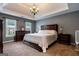 Comfortable primary bedroom suite with a tray ceiling, neutral carpet and paint, and lots of natural light at 405 Woodbrook Way, Lawrenceville, GA 30043