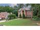 Beautiful brick home with lush green lawn and mature trees, creating a serene and inviting atmosphere at 405 Woodbrook Way, Lawrenceville, GA 30043