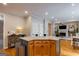 Kitchen island featuring wood cabinets, granite countertops with seating and hardwood flooring at 405 Woodbrook Way, Lawrenceville, GA 30043