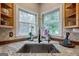 Corner kitchen sink with granite countertops, hardwood cabinets and windows overlooking back yard at 405 Woodbrook Way, Lawrenceville, GA 30043