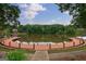 Stunning lake view from this home showcasing a curved wooden dock, lush trees, and blue skies at 405 Woodbrook Way, Lawrenceville, GA 30043
