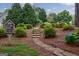 Charming stone pathway leading to a free little library, surrounded by lush landscaping at 405 Woodbrook Way, Lawrenceville, GA 30043