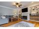 Cozy living room with hardwood floors, built-in shelves, a fireplace, and a comfortable sectional sofa at 405 Woodbrook Way, Lawrenceville, GA 30043
