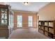 The living room features dual windows letting in natural light; plus storage shelving and a china cabinet at 405 Woodbrook Way, Lawrenceville, GA 30043