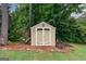 Well-maintained storage shed in a wooded backyard, providing ample space for outdoor equipment at 405 Woodbrook Way, Lawrenceville, GA 30043