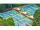 Aerial view of multiple outdoor tennis courts with covered seating areas surrounded by trees at 405 Woodbrook Way, Lawrenceville, GA 30043