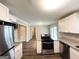 Well-lit kitchen with stainless steel appliances, granite countertops, and an adjacent living area at 3948 Regent St, Douglasville, GA 30134