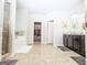 Bright bathroom featuring dual sinks, a soaking tub, a separate shower, and a walk-in closet at 1243 Polk Xing, Mcdonough, GA 30252