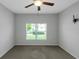Empty bedroom with a ceiling fan and a window showing a parked car outside at 1243 Polk Xing, Mcdonough, GA 30252