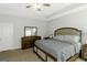 This bright and neutral bedroom has carpet and includes a ceiling fan and large comfortable bed at 1243 Polk Xing, Mcdonough, GA 30252
