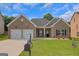 Charming brick home with a well-manicured lawn, two-car garage, and inviting front porch at 1243 Polk Xing, Mcdonough, GA 30252