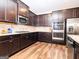 Stylish kitchen featuring granite countertops, stainless steel appliances, and dark wood cabinetry at 1243 Polk Xing, Mcdonough, GA 30252