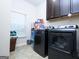 Laundry room featuring a modern washer and dryer, upper cabinets, and a window at 1243 Polk Xing, Mcdonough, GA 30252