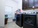 Laundry room featuring a modern washer and dryer, upper cabinets, and a window at 1243 Polk Xing, Mcdonough, GA 30252