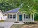 Charming home featuring a covered front porch, green door, and freshly landscaped front yard at 150 Glynn Addy Dr, Stockbridge, GA 30281