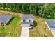 Front aerial view shows home with a charming entrance, garage, and lush lawn, set among neighboring houses and greenery at 340 Indian Lake Trl, Villa Rica, GA 30180